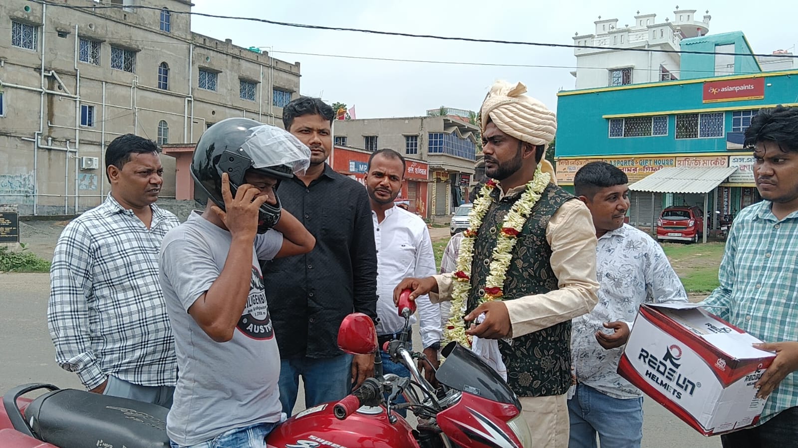 বিবাহ অনুষ্ঠান থেকে বর হঠাৎ রাস্তায় এসে হেলমেট ছাড়া মোটরসাইকেল আরোহীদের হেলমেট বিতরণ।